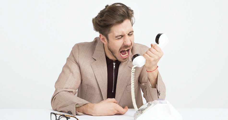 電話に向かって声を上げる男性