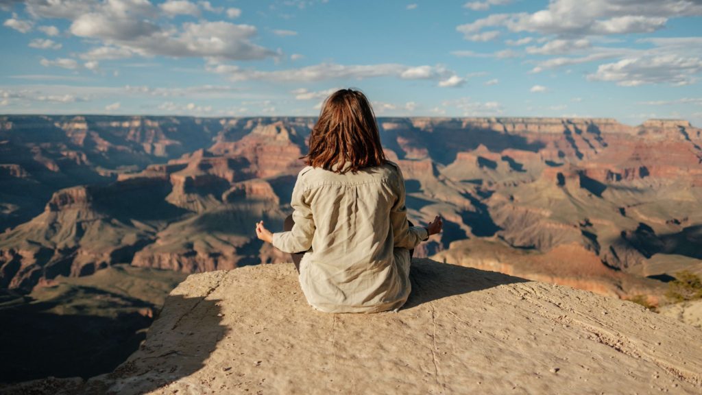 丘の上で瞑想する女性