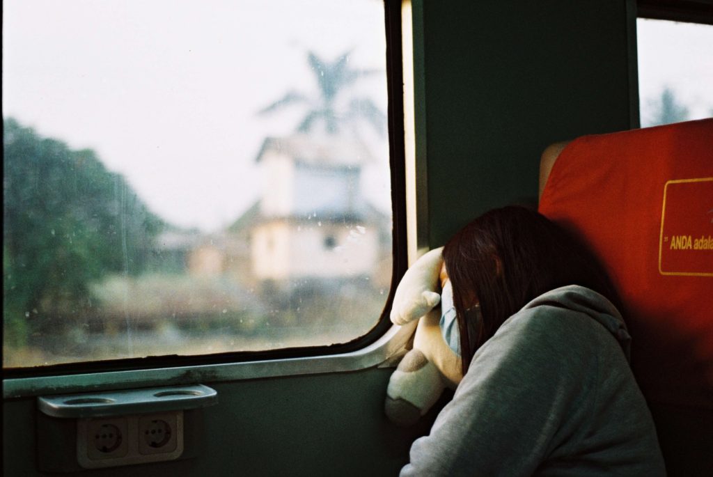 電車で眠そうにしている女性