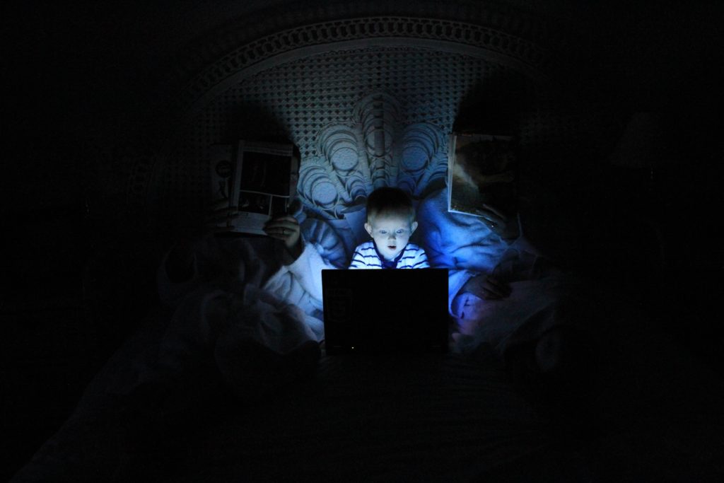 暗闇でパソコンを見る子供