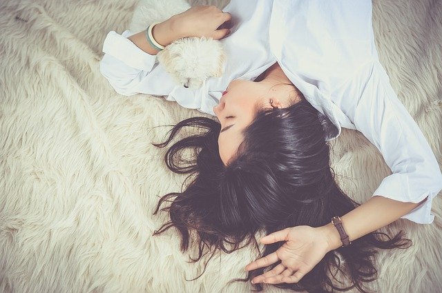 A woman sleeping with her dog