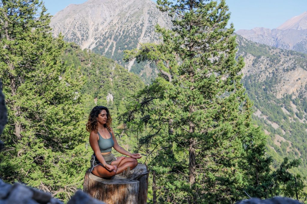 山林の高台で瞑想ずる女性