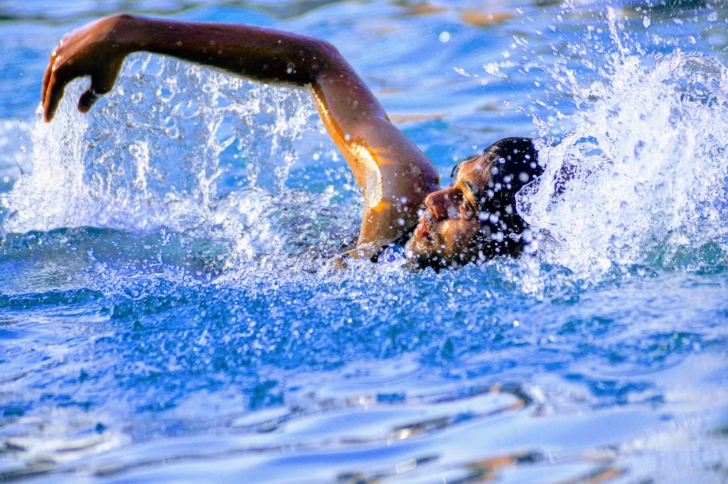 水しぶきを上げながら水泳している女性