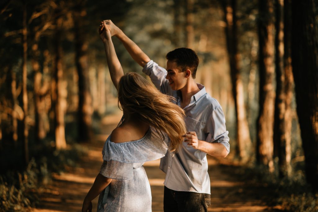 林道で手をつないで踊っている男女