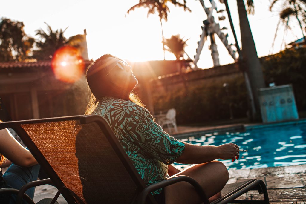 プールサイドで夕日を浴びている女性