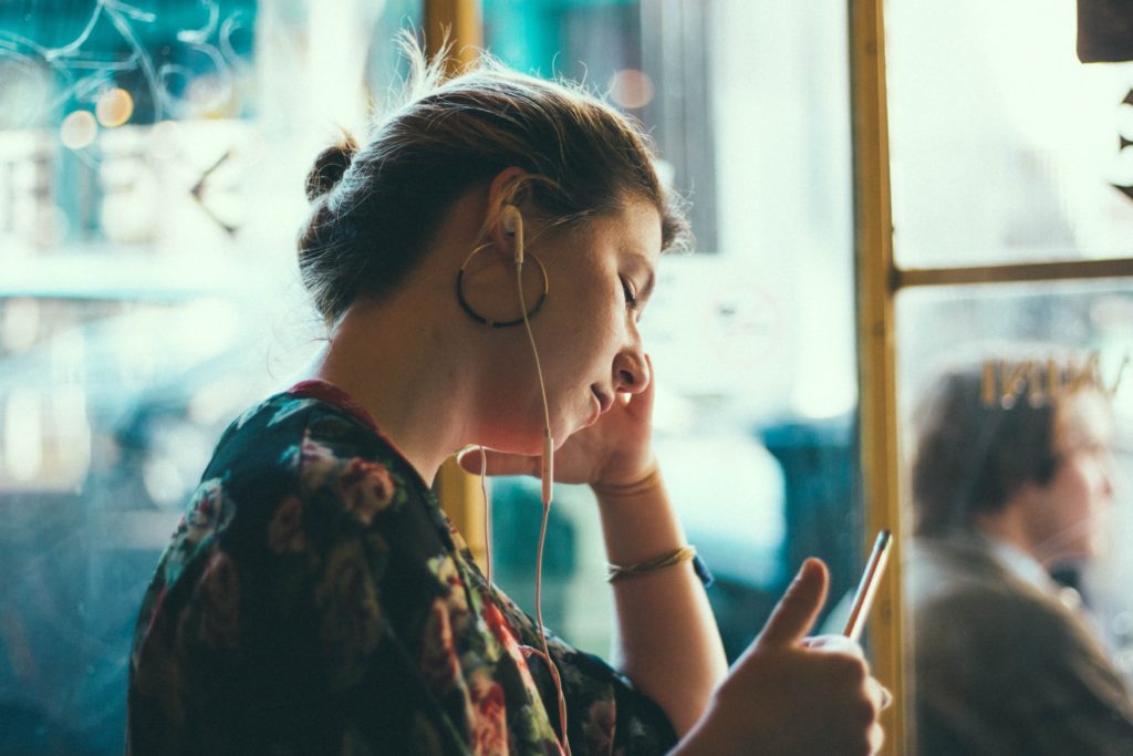 イヤホンで音楽を聴いている女性