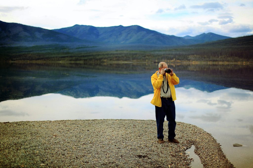 湖畔で一人写真を撮っている男性