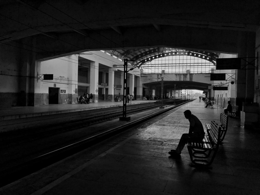 駅のホームで一人ベンチに座っている人