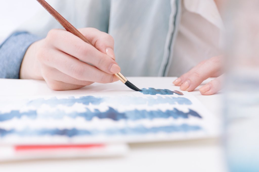 Painting blue lines on white paper