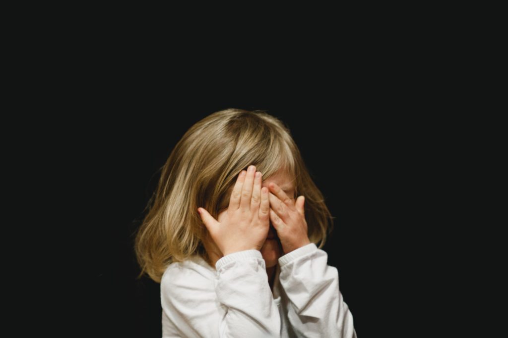 Young girl hiding her face