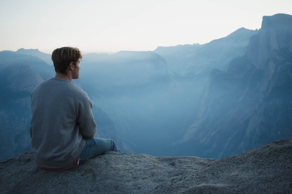 Man sitting alone on a mountain side