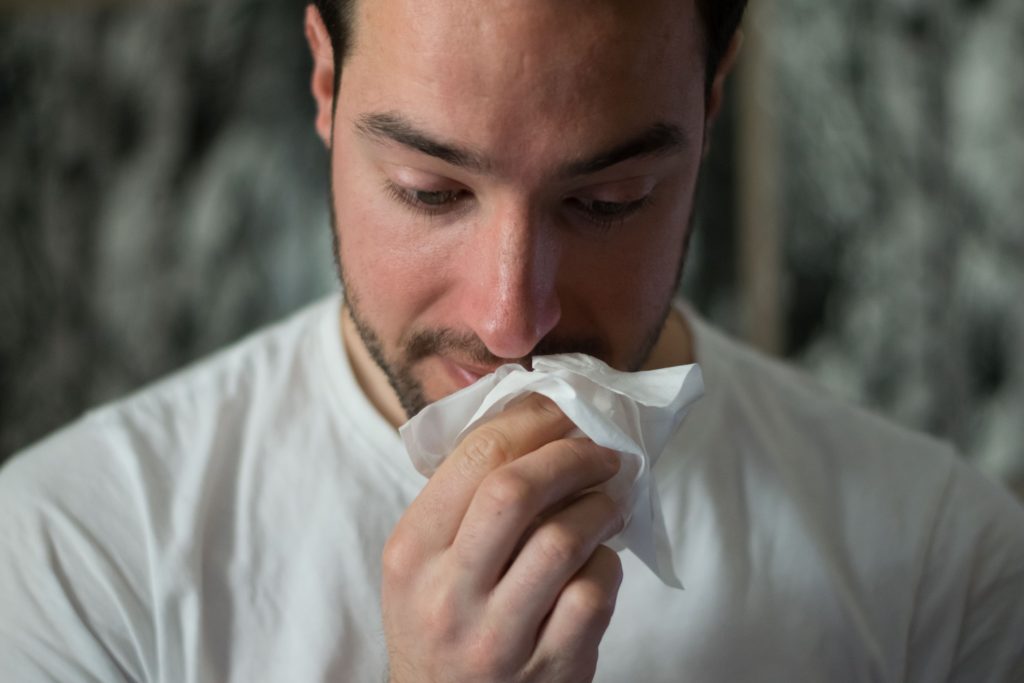 Man with a tissue to his nose