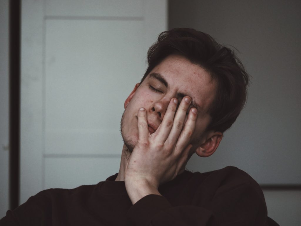 Stressed man with his hand to his face
