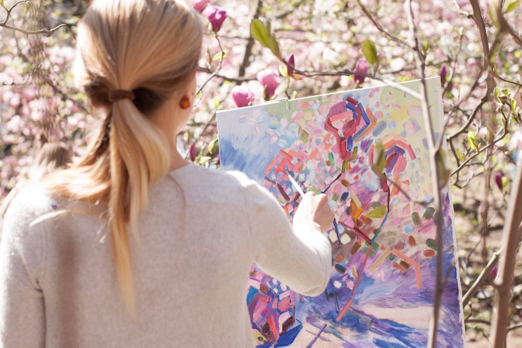 Woman painting flowers in the outdoors