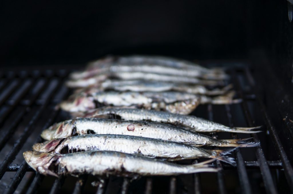 Blue-backed fish cooking on a grill