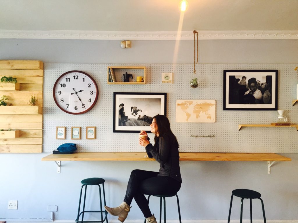 A woman enjoying her coffee break on a stool