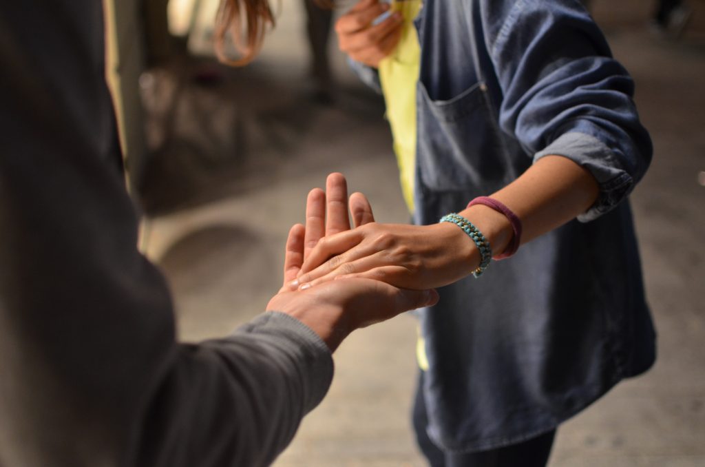 Two people holding hands and showing empathy