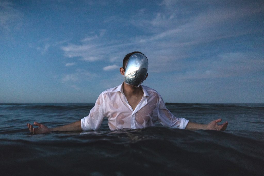 A masked person submerged in the ocean