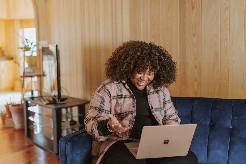 A woman happily interacting through her computer