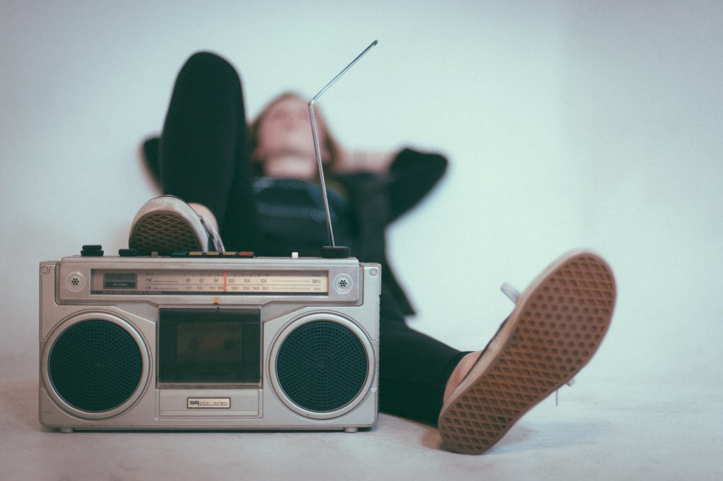 Man relaxing while listening to music from a boom box