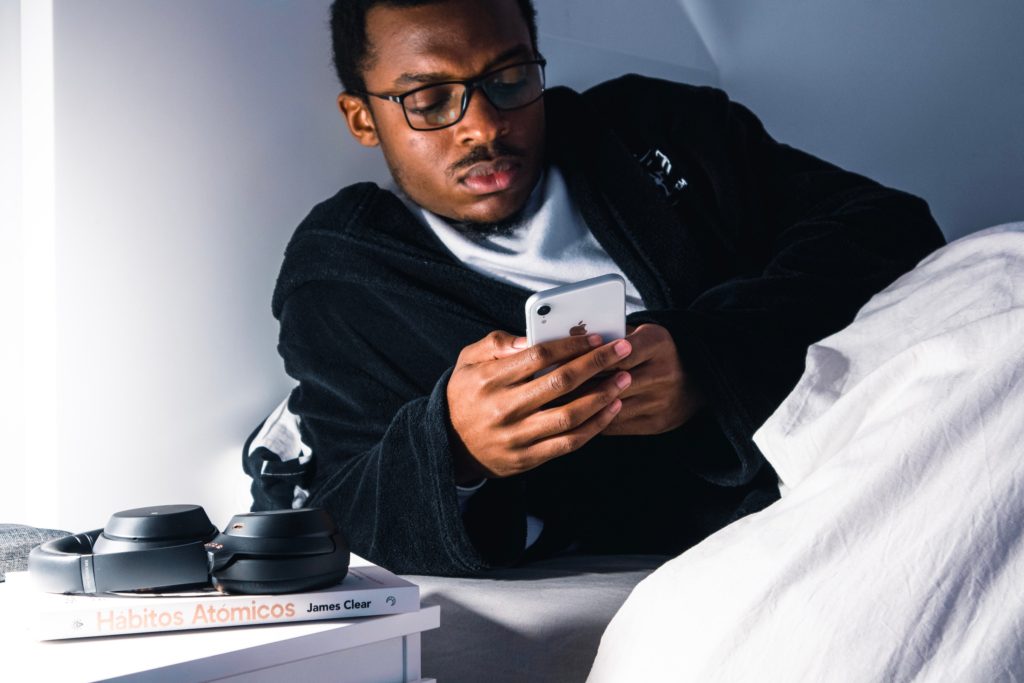 A restless man on his phone in bed