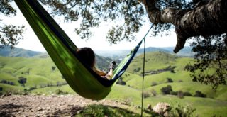 A woman laying on a hammock in nature